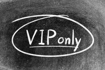 Fototapeta premium White chalk hand writing in word VIP (abbreviation of very important person) only and circle shape on blackboard background