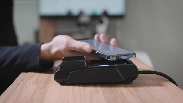 Close-up of a checkout terminal in a store. Contactless payment using a smartphone with the NFS function.
