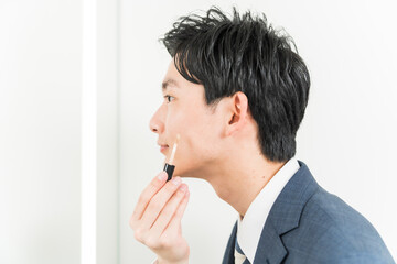 Fototapeta na wymiar コンシーラーを塗る若い日本人男性