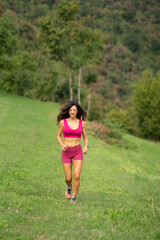 Trail running smiling girl runs uphill and on trail 