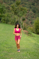 Obraz na płótnie Canvas Trail running smiling girl runs uphill and on trail 