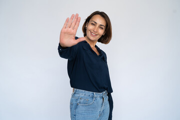 Happy woman showing palm. Female model in dark blue shirt making give me five gesture or playfully...