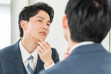 肌をチェックする若い日本人男性