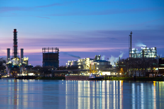Part of a chemical plant by a river early in the morning