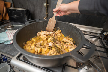 Rabbit meat cooking in a big pan on a kitchen indoor