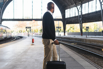 Black businessman standing on railway platform