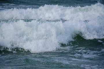 Surf wave with foam splashes on sea.
