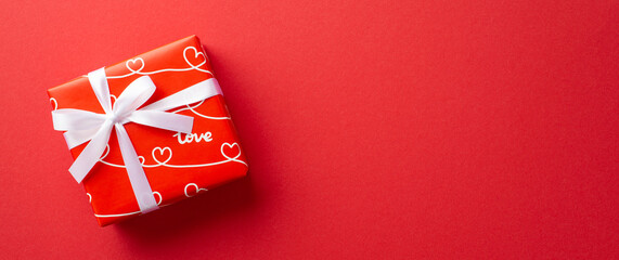 Valentine's Day concept. Top view photo of red giftbox with white ribbon bow on isolated red background with empty space