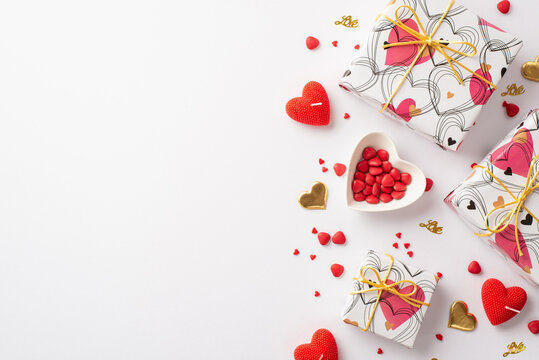 Saint Valentine's Day concept. Top view photo of present boxes heart shaped saucer with sprinkles candles and golden confetti on isolated white background with copyspace