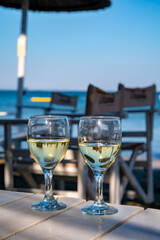 Drinking of cold white wine in beach bar, summer holidays, relax on sandy beach