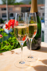 Drinking of French brut champagne sparkling wine in glasses in yacht harbour of Port Grimaud near Saint-Tropez, French Riviera vacation, France