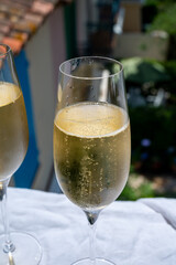 Drinking of French brut champagne sparkling wine in glasses in yacht harbour of Port Grimaud near Saint-Tropez, French Riviera vacation, France