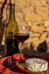 French wine and cheese pairing, glass of red beaujolais wine served with Saint-Félicien cow's milk...