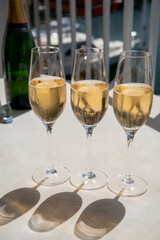 Drinking of French brut champagne sparkling wine in glasses in yacht harbour of Port Grimaud near Saint-Tropez, French Riviera vacation, France