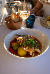 Provence cuisine, filet of seabass white fish served with potatoes, tomatoes and .Bouillabaisse jus in French restaurant