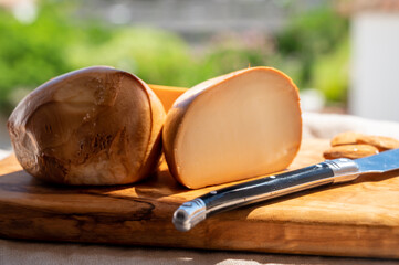 Italian yellow smoked cheese scamorza served on olive tree wooden plank