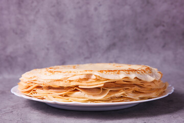Stack of thin pancakes on plate