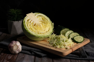Sliced cabbage and cucumber lie on the table in the kitchen 