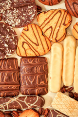 Close up of delicious bisquits and chocolate. Bisquits on plate top view, cookies on wooden empty space wood background. Macro sweets