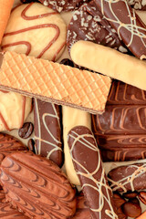 Close up of delicious bisquits and chocolate. Bisquits on plate top view, cookies on wooden empty space wood background. Macro sweets