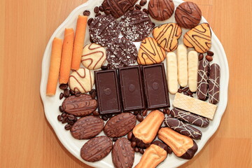 Various chocolate cakes on the table. Plate with completely vegan christmas bisquits, baked of wholemeal flour.