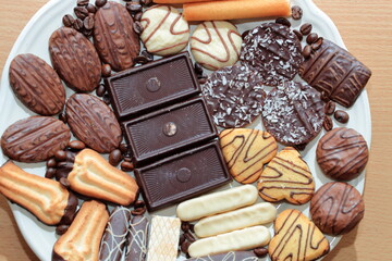 Close up of delicious bisquits and chocolate. Bisquits on plate top view, cookies on wooden empty space wood background. Macro sweets