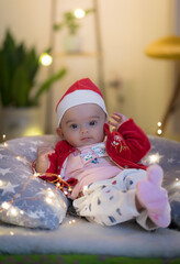 baby in santa hat sitting and posing on a pillow