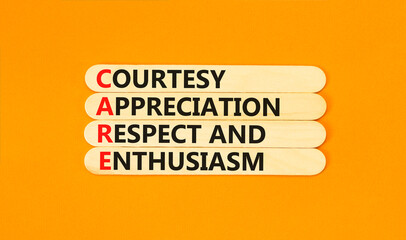 CARE symbol. Concept words CARE courtesy appreciation respect and enthusiasm on wooden stick on beautiful orange background. Business CARE courtesy appreciation respect enthusiasm concept. Copy space.