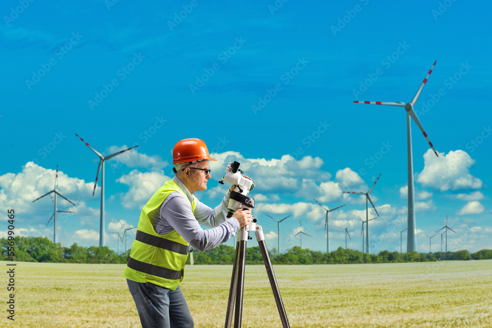 Wall mural Geodetic surveyor with a measuring equipment on a wind farm