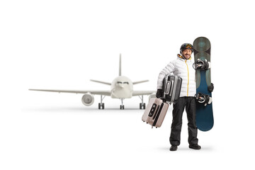 Full length portrait of a man with a snowboard and suitcases waiting for a flight