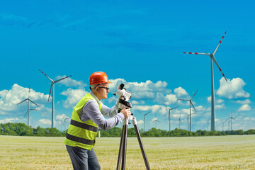 Geodetic surveyor with a measuring equipment on a wind farm