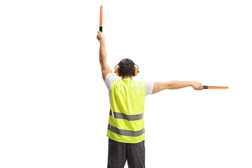 Rear view shot of an aircraft marshaller signalling with wands
