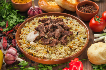 Homemade Uzbek pilaf from lamb served in cast iron cookware.