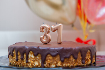 candles figures on chocolate cake on the background of balloons