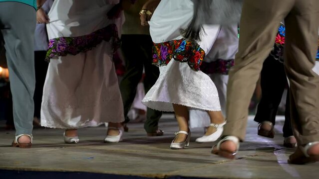 Closeup of men and women dancing a Mexican cultural folk dance sharing the different ethnic dances of the Yucatan in Merida in slow motion.