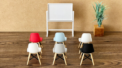 ミニチュアのホワイトボードの前に並べられた椅子_コルク背景