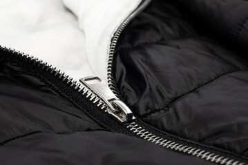 A lock with a silver zipper on a black background. Zipper
