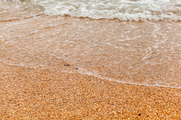 The seas are full on the sandy shore on a cloudy day. Rest on the sea. There is an empty space for text