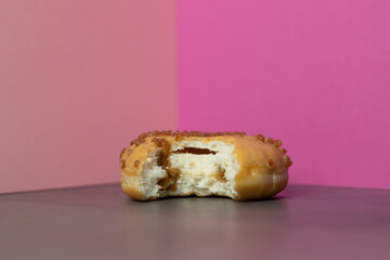 petit beignet fourré au caramel croqué sur fond rose