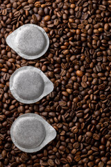 Paper pods for coffee machine on coffee beans background