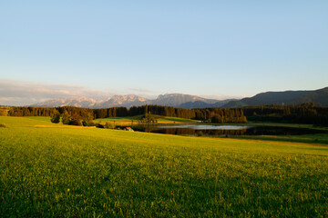 Fototapeta premium hiking trail overlooking scenic alpine lake Attlesee and the lush alpine valley with its endless green alpine meadows in the Bavarian Alps in Nesselwang, Allgaeu or Allgau, Bavaria, Germany