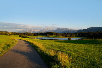 	
hiking trail overlooking scenic alpine lake Attlesee and the lush alpine valley with its endless green alpine meadows in the Bavarian Alps in Nesselwang, Allgaeu or Allgau, Bavaria, Germany