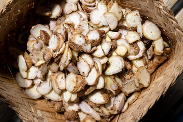 Fresh aromatic ginger slices are aerated in a woven bamboo container.