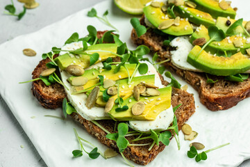 toasts with rye bread, sliced avocado, cheese. Delicious breakfast or snack, Clean eating, dieting, vegan food concept. top view