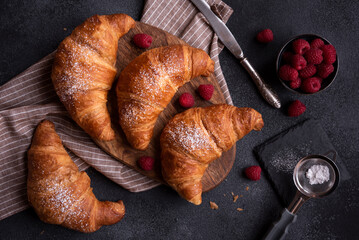 Delicious sweet croissant with fresh fruit on dark background