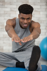 man at the gym doing stretching exercises