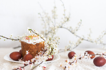 Easter cake and painted eggs. Blooming bouquet laying on the table near.
