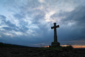 Krzyż katolicki bruśnieński na tle kolorowego nieba.