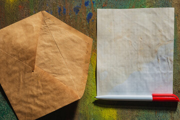 Postal envelope and sheet of paper on a dark wooden background. We are happy with the autumn mood