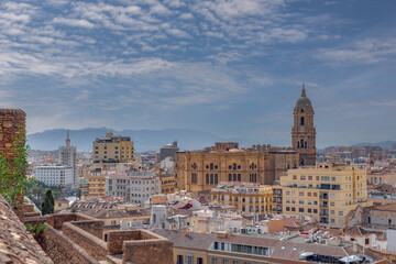 Naklejka na ściany i meble Amazing panorama of Malaga city center, seaport and marina on a beautiful sunny day with blue sky above. Scenic view of the Malaga from the Alcazaba citadel located on the hills. Andalusia, Spain.